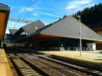 Blick auf das riesige Bahnhofsgebäude des Bahnhofs Tarvisio Boscoverde am 25.10.2015.
Auch wenn das Gebäude riesig ist, herrscht darin meist gähnende Leere. 
Als ich vor ein paar Jahren zu ersten mal in das Gebäude ging, war das einzige, was man hörte, einen Tick einer Uhr. Vor zwei Jahren wurde zudem auch noch der Ticketschalter geschlossen, jetzt gibt es hier nur noch einen einzigen Automaten. Als ich dieses Jahr den Bahnhof besuchte kam immerhin durch die Ankunft des einem der zwei tagsüber verkehrenden Fernreisezuüge, dem EC 31 (Wien Hbf - Venezia S. Lucia) wieder ein wenig leben in das Gebäude.
Allgemein ist der Personenverkehr auf der neuen Pontebbana kläglich.
Montag bis Freitag fahren gerade mal 12 Züge in Tarvisio ab, an Samstagen 14 und an Sonntagen 13.
Betrachtet man die Anzahl der Züge, muss man zugeben, dass dies für eine zweigleisige Hochleistungsstrecke zu wenig ist.
Es bleibt also nur zu hoffen, dass die FS in Hinsicht auf den internationalen Verkehr einmal umdenkt und in Tarviso Boscoverde einmal mehr Verkehr herrschen wird, denn wenn der Verkehr so mickrig bleibt, ist der Bau der neuen Pontebbana genauer betrachtet nur Geldverschwendung.