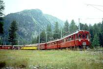 RhB Aussichtswagen-Extrazug 3962 f�r RH�TIA TOURS von Alp Gr�m nach Pontresina am 30.08.1996 in Morteratsch mit Triebwagen ABe 4/4 I 34 - ABe 4/4 I 30 - D� 4035 - B� 2093 - B� 2097. Hinweis: Die beiden Triebwagen sind inzwischen in gelb umlackiert, Probleml�sung wegen �berl�nge des Extrazuges: Zug 441 f�hrt auf Gleis 1 ein, Zug 3962 zieht auf Streckengleis Pontresina vor und wartet Einfahrt Zug 464 auf Gleis 2 ab. Nach Ausfahrt von Zug 441 setzt Zug 3962 auf Gleis 1 zur�ck und wird von Zug 464 �berholt, gescanntes Dia.
