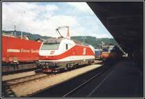 1012 002 wartet im Juli 2000 auf neue Aufgaben, w�rend auf dem Nachbargleis die 1044 201 mit dem Autoreisezug Wien-Feldkrich durch den Bahnhof rollt.