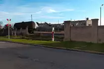 Blick auf ein völlig zerfallenes Gebäude des alten Güterbahnhofes von Nordhausen an dieser Stelle kreuzt auch der Gleisanschluß von Nordbrand Nordhausen (Schnaps und Industriealkohol) die Straße. An dem rot-weißen Pfosten befindet sich ein Knopf um das vorherige nicht existente DDR-Andereaskreuz aufleuchten zu lassen Nordhausen 26.12.2015