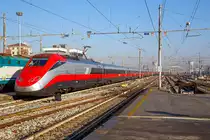 
Ausfahrt eines sehr langen  Frecciarossa  (deutsch: roter Pfeil) der Trenitalia (100-prozentige Tochtergesellschaft der Ferrovie dello Stato (FS)) am 29.12.2015 vom Bahnhof Milano Centrale (Mailand Zentral). 

Der Frecciarossa ist eine Zuggattung für Züge mit einer Höchstgeschwindigkeit von 300 km/h. Hier ist es der ETR 500 - 56 ein ETR 500 der 2.Serie. ETR steht ElettroTreno Rapido. 