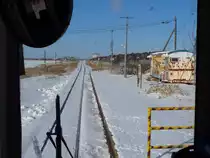 Die Hanasaki-Linie, Asiens östlichste Bahnlinie: Die Haltestelle Hanasaki, Blick nach Westen. Der alte Güterzugbegleitwagen alias Bahnhof rostet in der gefrorenen Landschaft still vor sich hin. Von der Einstiegsplattform des Triebwagens KIHA 54 519 mit vereisten Fenstern aus, 19.Februar 2009. 