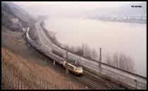 Mit einer bunt gemixten IC Garnitur war am 10.3.1993 um 10.58 Uhr die 103185 im Rheintal bei Boppard in Richtung Süden unterwegs.