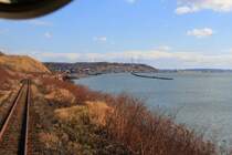 Hanasaki-Linie, Anfahrt auf das abgelegene Städtchen Akkeshi. Ueberall an der Pazifik-Küste verläuft die Strecke in sehr gefährdeter Lage; Sturm, Wellen oder gar Tsunami unterspülen oft die Geleise. Aus Triebwagen KIHA 54 523, 26.Oktober 2015.  