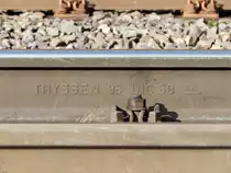 Walzzeichen einer UIC60 (neue Bezeichnung 60E2) Schiene, gewalzt von Thyssen Krupp im Jahr 1996 mit gehärteten Schienenkopf. Die Schienenbefestigung ist hier der KS-Bau.

Allrath 06.02.2016