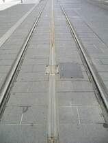 In der Altstadt von Bordeaux wollte man bei der Wiedereinf�hrung der Stra�enbahn  unter allen Umst�nden eine Oberleitung vermeiden. Daher gibt es nur auf den Au�enstrecken eine Oberleitung. 
In der Innenstadt gibt es das Mittelleitersystem APS (Alimentation par Sol).
Das System besteht aus jeweils 8 Meter langen Stromschienen,die nur  dann unter Strom gesetzt werden, wenn ein Zug dar�ber f�hrt.
So ist das Betreten der Schiene in der Mitte gefahrlos m�glich.
Die Z�ge haben jeweils zwei Schienenschleifer (�hnlich wie bei M�rklin) zur Stromabnahme.
Das System funktioniert allerdings nicht ohne Probleme.

19.09.2004
Bordeaux

