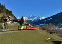 Ge 4/4 II 611 mit einem RE am 19.03.2016 bei Serneus. 