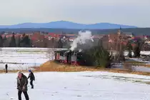 Vor der beeindruckenden Kulisse des Brockenmassivs, beeilen sich am Nachmittag des 14.02.2015 noch die letzten Fotografen, die Fotolinie zu erreichen, während 99 6101 und 99 5901 ihren IG HSB-Sonder-PmG, zur Vorbereitung einer Scheinanfahrt, kurz hinter Hasselfelde, einige hundert Meter zurückdrücken.