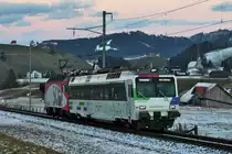 In der Dämmerung des Tages 5.1.2016 fährt das Gespann Re 456 016 und der Triebwagen RBDe 561 081 anlässlich einer Probefahrt zur Höfner Narrenfahrt bei Schwyzerbrugg vorüber.