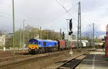 Die Class 66 266 026-4 von Railtraxx kommt mit einem langen Coilzug aus  Antwerpen-Waaslandhaven(B) nach Linz-Voestalpine(A)  und fährt in Aachen-West ein. 
Aufgenommen vom Bahnsteig in Aachen-West. 
Bei Sonne und Regenwolken am Nachmittag vom 7.4.2016.