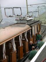 Blick auf die Stromabnehmer und die Dachausr�stung einer Drehstromlok auf dem Gipfel.
Die Loks haben eine Holzverkleidung und die Wagen einen Holzaufbau.
23.09.2004