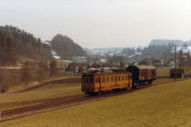 ASM/OJB/LMB: EINST UND JETZT. Die LMB-Strecke Langenthal-Melchnau wurde im Jahre 1917 eröffnet. Im Jahre 1982 erfolgte die Umstellung des Personenverkehrs zwischen St. Urban und Melchnau auf Busbetrieb. Eine Verlängerung des Bahnbetriebes bis St. Urban Ziegelei erfolgte 1989. Für den Güterverkehr (Normalspurwagen auf Rollböcken) sowie Personen-Extrazüge konnte die Strecke nach Melchnau weiterhin betrieben werden. Die Aufhebung der Konzession für den Streckenabschnitt St. Urban Ziegelei-Melchnau Fabrik erfolgte im Jahre 2012 sowie der Abbau von Geleisen und Fahrleitung im Winter 2015.
Güterzug mit dem OJB De 4/4 53 (ehemals LMB CFe 4/4 6) auf der Fahrt von Melchnau nach Langenthal im März 1984.
Foto: Walter Ruetsch    