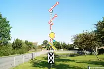 06.06.2016; 19:12 Uhr..... Kommt man von der B106 über die L031 nach Bad Kleinen, dann wird man am Ortseingang von Formsignalen des H/V-Systems begrüßt, die 'Langsame Fahrt' anzeigen. Zunächst dachte ich, dass soll eine Mahnung an Autofahrer sein, im Ort nicht zu rasen, doch wer weiß schon um die genaue Bedeutung schräg stehender Signalflügel. 
Ein Anruf beim Gemeindeamt brachte zu Tage, dass die Gemeinde diese Signale aufstellen ließ, um damit an die frühere Bedeutung des Eisenbahnknoten Bad Kleinen zu erinnern. In gewisser Weise also ein Mahnmal gegen den allerorten praktizierten Rückbau von Bahninfrastruktur. 