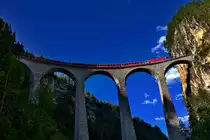 Die Ge 4/4 III 651 überfährt abends mit einem Re aus Chur nach St.Moritz das Landwasserviadukt in Filisur.Bild vom 23.6.2016