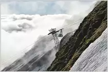 Ein herrlicher Tag beginnt auf dem Brienzer Rothorn. Neben der Dampfzahnradbahn von Brienz gibt es noch die Luftseilbahn von der andern Seite aus Sörenberg. Schon früh verlässt die erste Gondel, noch als Leerfahrt, das Rothorn und verschwindet im Nebelmeer. (20.06.2016)