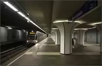 Im Untergrund von Rotterdam -

Die dreigleisige Station Marconiplein an der hauptsächlich in Ost-West-Richtung durch Rotterdam verlaufenden Calandlijn. Der erste Abschnitt dieser zweiten Rotterdamer Metrolinie wurde 1982 eröffnet. 1983/84 wurde die Linie in Richtung Nordosten erweitert, aber als Stadtbahn (Sneltram) in Niveaulage mit Kreuzungen durch Auto- und Fußgängerverkehr. Auf diesem Sneltram-Abschnitt erfolgt die Stromzufuhr über Oberleitungen und nicht über Stromschienen wie im 'echten' Metrobereich.

Die unterirdische Verlängerung nach Westen bis zu der Station Marconiplein ging 1986 in Betrieb. Hier kann zu einigen Straßenbahnlinien umgestiegen werden. Die Station hat drei Gleise, wobei das dritte Gleis nur einen Hilfsbahnsteig hat, links auf dem Bild erkennbar. Gestalterisch wirksam sind die später eingebauten pilzförmigen Verkleidungen der Stützen mit indirekter Beleuchtunggen an der Decke. 

2002 wurde ab hier die Strecke über Schiedam und das Hafengebiet bis Tussenwater verlängert, von wo die Calandlijn gemeinsam mit der Erasmuslijn bis Spijkenisse de Akkers verkehrt.

21.06.2016 (M)