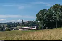 Ein DOMINO-Pendelzug fährt am 7. Juli 2016 bei Mézières als RE in Richtung Bulle. Im Hintergrund das Städtchen Romont.