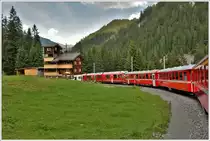 Oberhalb Litirüti beschreibt die Arosabahn eine langgezogene S-Kurve und passiert dabei dieses aussergewöhnliche Holzhaus. (06.07.2016)