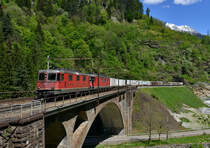 Eine Re 10/10 mit einem Güterzug am 20.05.2016 bei Faido. 