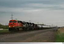 Mit einem aus mehr als hundert Kesselwagen gebildeten Güterzug sind am 9. Mai 2016 Burlington Northern and Santa Fe Railway # 7506 (GE ES44DC), Norfolk Southern # 1119 (EMD SD70ACe) und Norfolk Southern # 1122 (EMD SD70ACe) in Minnesota unterwegs.