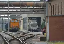 Teleaufnahme auf eine V60 in Staßfurt im Sodawerk. Rechts hinter der Mauer sind Teile einer Dampfspeicher Lok zu erkennen.

Staßfurt 20.07.2016