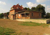 Die ehemalige Güterverladerampe mit dem Bahnhofsgebäude am 10.09.2016 in Laucha. Von den früheren Güter- und Rangiergleisen ist nichts mehr zu sehen.