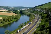 Von den Weinbergen zwischen Karlstadt und Himmelstadt herab ergeben sich reizvolle Ausblicke auf das Maintal und die entlang des Mains verlaufende Bahnlinie. ES 64 U2 068 der WLC fährt mit ihrem DGS 41133 von Rheinhausen nach Budapest Sorok am Morgen des 03. Juli 2014 südwärts. Im Hintergrund das Zementwerk der Firma Schwenk in Karlstadt, links erkennt man die Ortschaft Laudenbach.