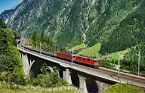 Re 4/4 II 11252 und Re 6/6 11609  Uzwil  sind mit einem Güterzug, auf der mittleren Meienreussbrücke, talwärts unterwegs.
Aufgenommen am 19.7.2016. 