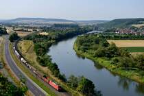 Ein Blick in die andere Richtung, auf der es viele Details zu entdecken gibt: Den Ort Himmelstadt mit der Staustufe, an der Schleuse wartet gerade ein Hotelschiff auf die Weiterfahrt. Ganz im Hintergrund erkennt man eine Talbrücke der NBS Würzburg - Hannover. 152 158 fährt mit dem EZ 51714 Nürnberg Rbf nach Mannheim Rbf auf Karlstadt zu (03. Juli 2014).