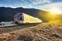 Der Bahnhof Abfaltessbach, ist eine der wenigen Stellen an der Pustertaalbahn, wo im Winter nachmittags noch die Sonne hereinscheint.
Hier fährt soeben ein ETR 170 des Landes Trentino, angestrahlt von der Sonne, als REX 1867 von Fortezza/Franzensfeste nach Lienz, aus dem Bahnhof Abfaltesbach aus.
Aufgenommen am 4.12.2016.