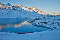 Am Morgen de 28.12.2016 fährt der RhB Triebzug ABe 8/12 3512 am schwarzgefrorenen Lago Bianco entlang.