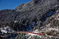 Der RhB Triebzug ABe 8/12 3509 fährt mit einem Re aus Chur nach St.Moritz über das Schmittentobelviadukt in Filisur.Bild vom 9.1.2017