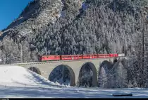 Der Schlittelzug überfährt am 9. Januar 2017 den Albulaviadukt II auf Leerfahrt von Preda nach Bergün. <br>
Aufgrund eines defekten Steuerwagens verkehrt der Schlittelzug Bergün - Preda derzeit mit Sandwichbespannung. Zum Einsatz kommt die Ge 4/4 II 616  Filisur  in Siemens-Werbeanstrich sowie als Ersatz für den Steuerwagen die Ge 4/4 II 613  Domat/Ems . <br>
Das Bild entstand nur wenige Meter neben der im Winter gesperrten und als Schlittelweg präparierten Albulapassstrasse.