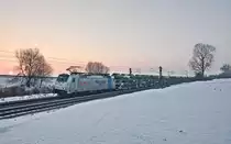 Die 186 423-0 fährt kurz vor Sonnenuntergang in Langenisarhofen mit einem Autozug südwärts.Bild vom 21.1.2017