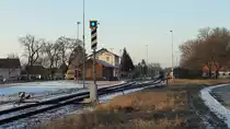 Bad Radkersburg, Ausgangsbahnhof der 31 km langen Radkersburger Bahn nach Spielfeld, 2017-01-20
Auf dem Bild: Ein Weichenüberwachungssignal.Ein blaues Licht auf einer
schwarzen quadratischen Tafel mit gelbem rückstrahlenden Rand.
Der Signalmast zeigt schräg nach rechts steigende schwarze Streifen auf weißem
rückstrahlendem Grund.
Das Signal wird für Betriebsstellen mit Rückfallweichen verwendet