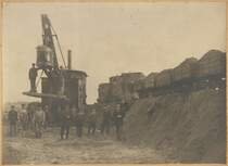 Ab ca. 1917 erfogte in und um den Bahnhof Rheda der Ausbau der ehemals zweigleisigen Hauptbahn Hamm - Rheda - Bielefeld mit der gleichzeitigen Anlage eines Hochdammes. Auf diesem Originalfoto sind ein Sandbagger und eine Feldeisenbahn abgebildet, mit welchen der ben�tigte Sand aus den weit entfernten D�nenw�lder geholt und zum Dammbau genutzt wurde. 
