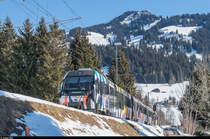 Der Zug mit dem Be 4/4 5001 wirkt derzeit als Kunstobjekt in der Ausstellung  Elevation 1049  in Gstaad mit. Der Zug wurde von der Künstlerin Sarah Morris neu gestaltet, inspiriert von der Raupe des Monarch-Schmetterlings. <a href= https://www.elevation1049.org/de/gstaad/sarah-morris/monarch.html >https://www.elevation1049.org/de/gstaad/sarah-morris/monarch.html</a><br>
Ausfahrt aus der Station Gruben in Richtung Gstaad am 13. Februar 2017.