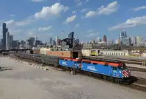 Die Metra  F40PH 105 und 122 bespannten am Nachmittag des 25. April 2016 Z 917 (HC) Heritage Corridor von der Chicago Union Station nach Joliet und wurden von mir vor der Chicagoer Skyline fotografiert. Markantestes Gebäude ist zweifelsohne der 527,3 Meter hohe Seas Tower (ab 2009 Willis Tower), sowie der Trump International Hotel & Tower mit 423 Metern und das 346 Meter hohe  Aon Center.