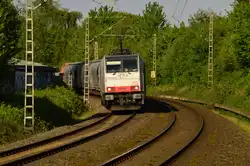 Mit einem Selbstentladewagenzug kommt hier die Railpoollok 186 110 am heutigen Abend durch Jüchen gen Rheydt gefahren.