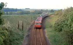 Interessant ist auch diese Zugbildung mit Lok in der Mitte, bei der der Schienenbus einem geschobenen Wendezug angehängt wurde (bei Dorheim, 16.5.1985).