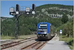 Der SNCF X 73657 verlässt als TER 895511 auf dem Weg von Dole nach St-Claude den Bahnhof von Morez und fährt dabei an der markanten Signalbrücke vorbei, darunter - wie bei