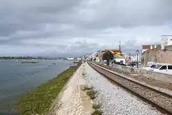 FARO (Distrikt Faro/Concelho Faro), 12.03.2022, Linha do Algarve kurz vor dem Bahnhof Faro; rechts ist die Mauer um die Altstadt zu sehen; Aufnahme von einem Bootsanleger, der über das Gleis