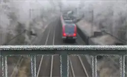 Mal den Fokus auf dem Brückengeländer -     Im Hintergrund eine S-Bahn der Linie S2 in Fahrtrichtung Schorndorf bei Kernen im Remstal.
