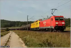 Ein buntes Gespann war 185 299 mit einem Baufahrzeg (Speno???) im Schlepp vor einem gemischten G�terzug.