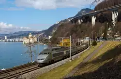 TGV Lyria (112) der Verbindung Paris–Dijon–Lausanne–Brig bediehnt, er f�hrt hier am 26.02.2012 bei  Clos du Moulin am Genfersee Richtung Brig entlang, hinten Ch�teau de Chillon,