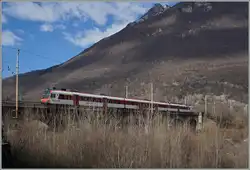 Der IR 3315 von Brig nach Domodossola fährt über die den Fluss Bogna überquernde Brücke und erreicht in Kürze sein Ziel Domodossola.