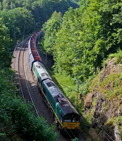 Diese zwei Class 66 (JT42CWR) Lokomotiven der Ascendos Rail (vormals CBRail) schieben den sehr langen Ganzzug von leeren VTG Selbstentladewagen (Falns), vorne zieht die HGK 185 589-9, hier am