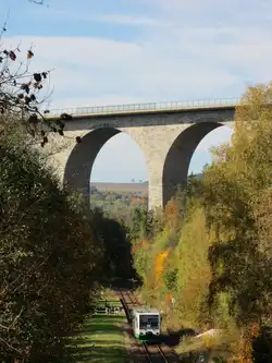 19.10.2013 13:29 VT 33 der Vogtlandbahn wegen SEV aus Oelsnitz (Vogtland) nach Plauen (Vogtland) Oberer Bahnhof vor der Kulisse der Elstertalbr�cke am Bedarfshalt Pirk.