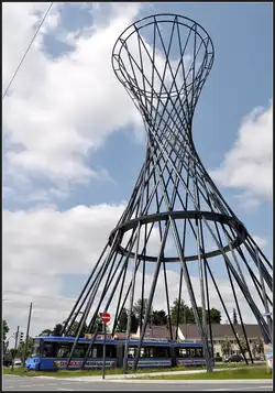 Unter der Skulptur hindurch -     Eine Tram durchfährt das Kunstwerk 
