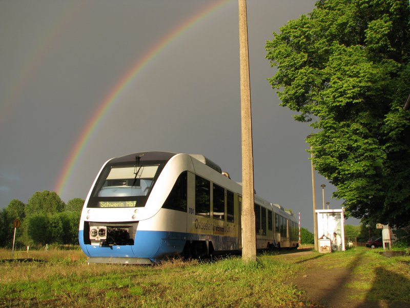 VT 704 der Ola hlt in Plate fr kurze Zeit mit einem Regenbogen im Hintergrund .